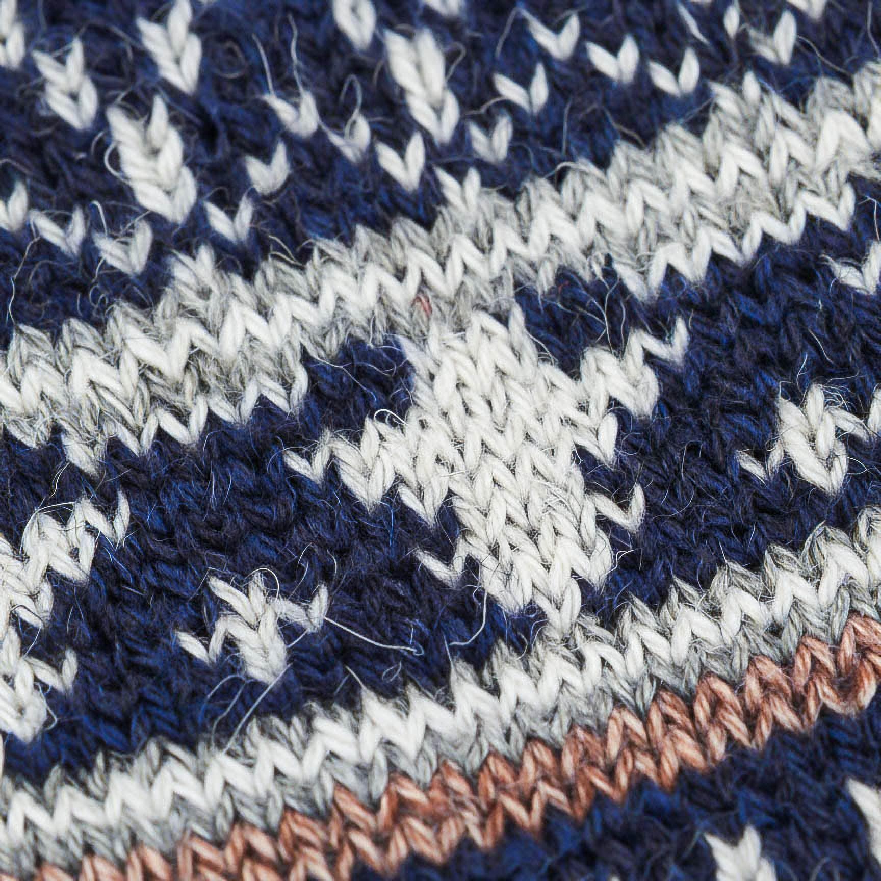 Close-up of a merino wool Swoollies socks knitted fabric with navy blue, white, and brown pattern