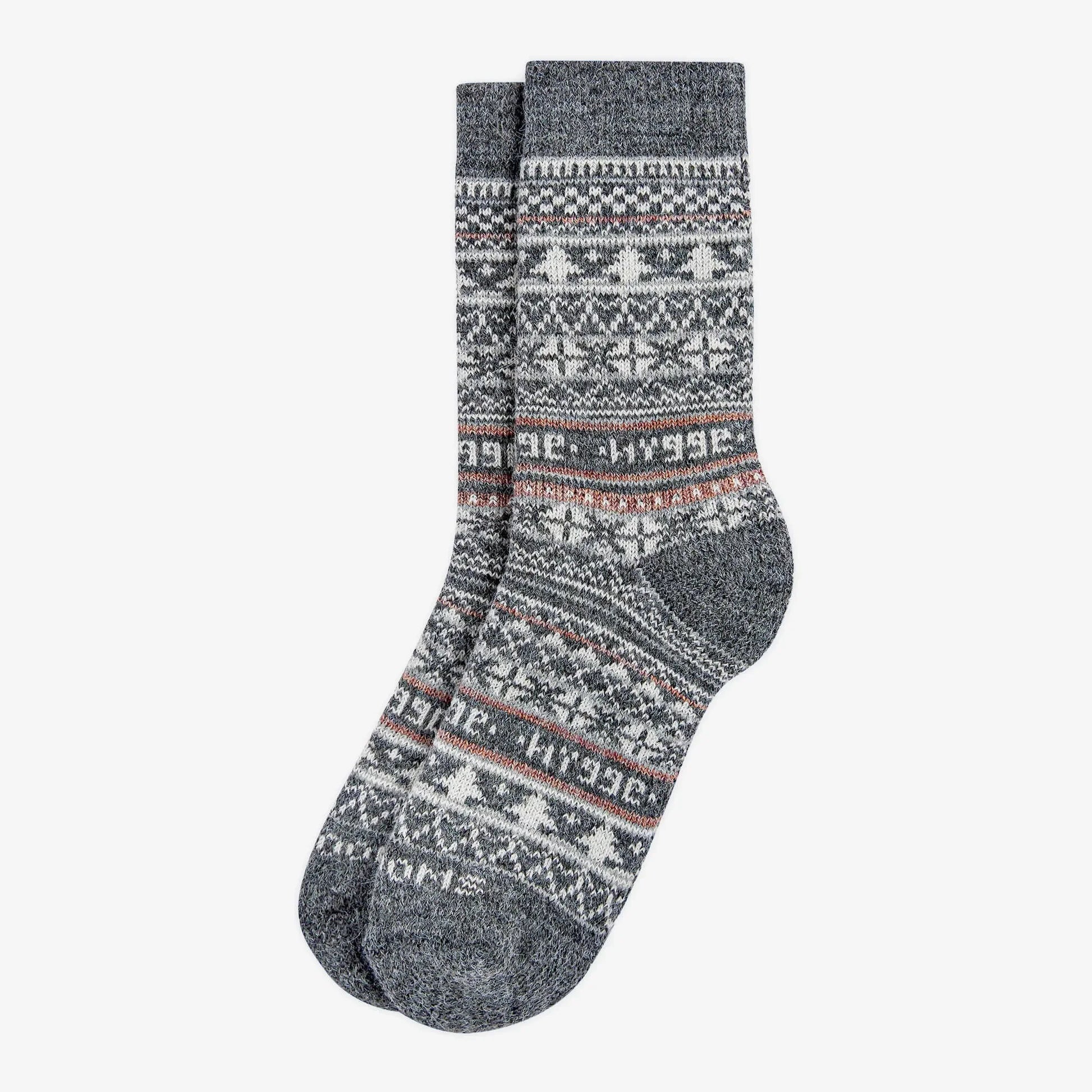 Grey patterned merino wool Swoollies socks with the text 'hygge' knitted on it. The socks are thick. Socks are on a light grey background